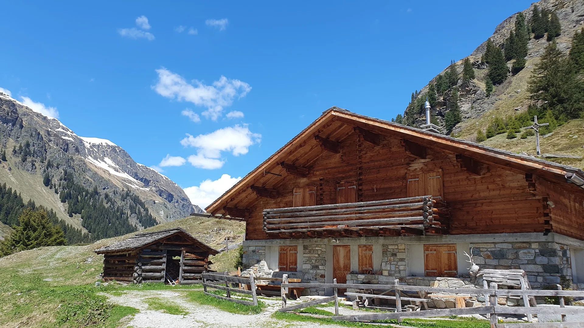 Die Alphütte und der Stall der Alpe Garnera im Sommer vor der Bergflanke des Garneratals